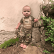 Load image into Gallery viewer, Baby wearing Multicam Tactical Combat Uniform with flak jacket design and US flag, standing outdoors.
