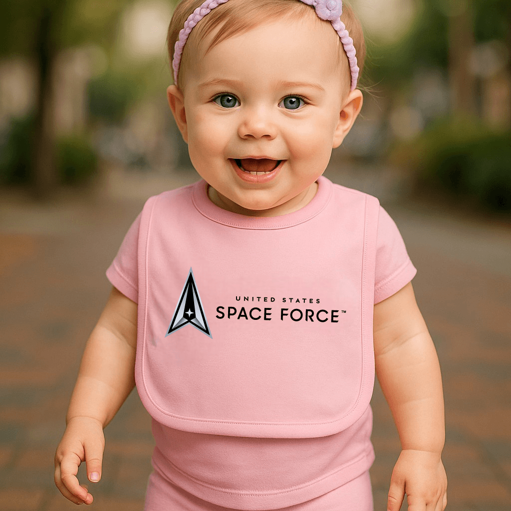 Baby wearing a pink Space Force bib by Trooper Clothing, smiling outdoors.