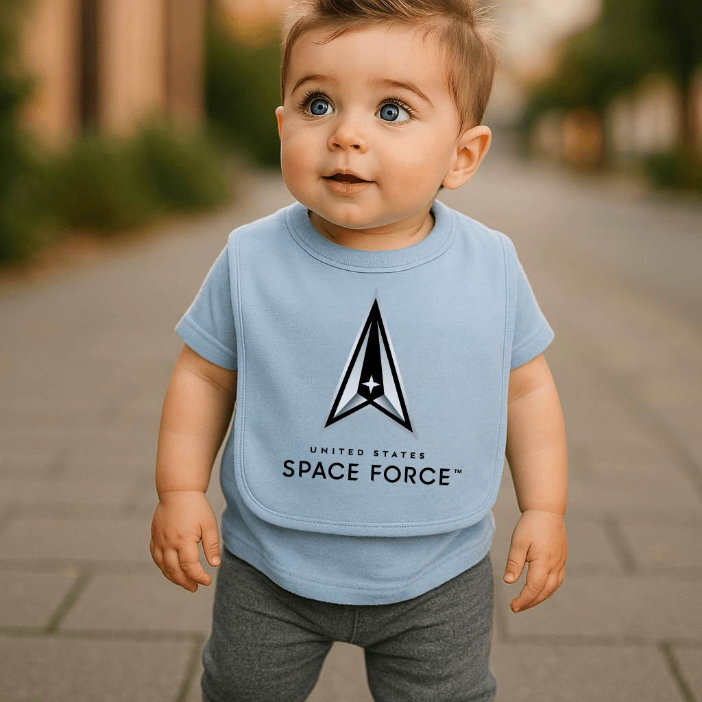 A happy baby wearing the Space Force Boys Baby Bib by Trooper Clothing while standing on a pathway.