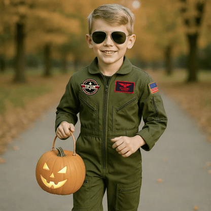 Youth aviator glasses worn by a boy in a flight suit holding a Halloween pumpkin on a path.