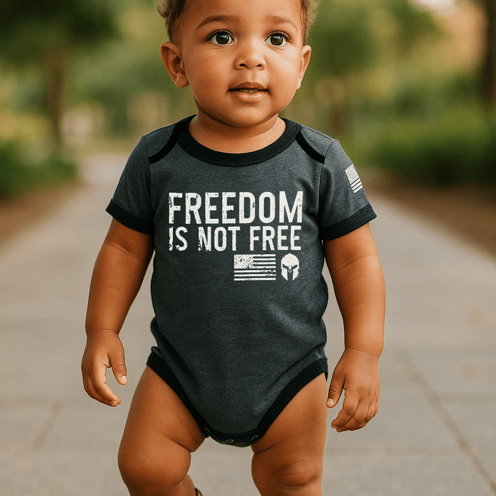 Baby wearing a graphite gray bodysuit with "Freedom Is Not Free" print and American flag on the sleeve.