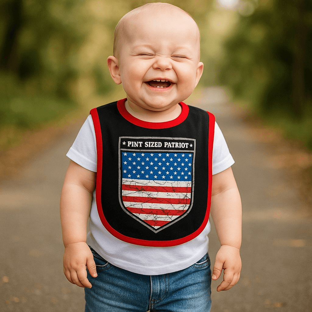 Bib Pint Sized Patriot Baby smiling in a cute cotton bib with red and blue graphic on a sunny path.