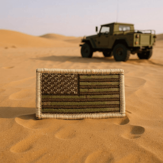 Multicam American Flag Patch in a desert landscape with a military vehicle in the background.