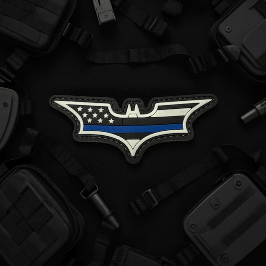 Blue Line Batman Patch displayed on a dark background surrounded by tactical gear and accessories.