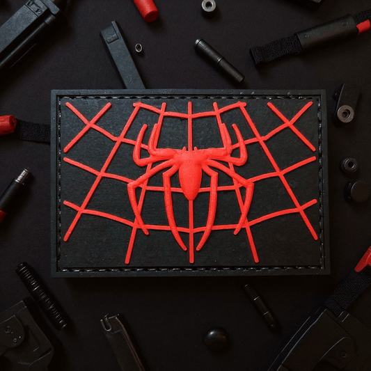 Spiderman web chest logo patch on a black background, featuring a red spider design and web pattern.