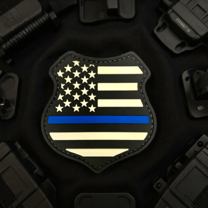 Thin Blue Line Shield Patch featuring a black PVC design with white stars and bars and a blue line.