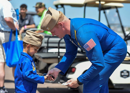 Trooper Clothing youth blue flight suit with garrison cap worn by a child interacting with a pilot